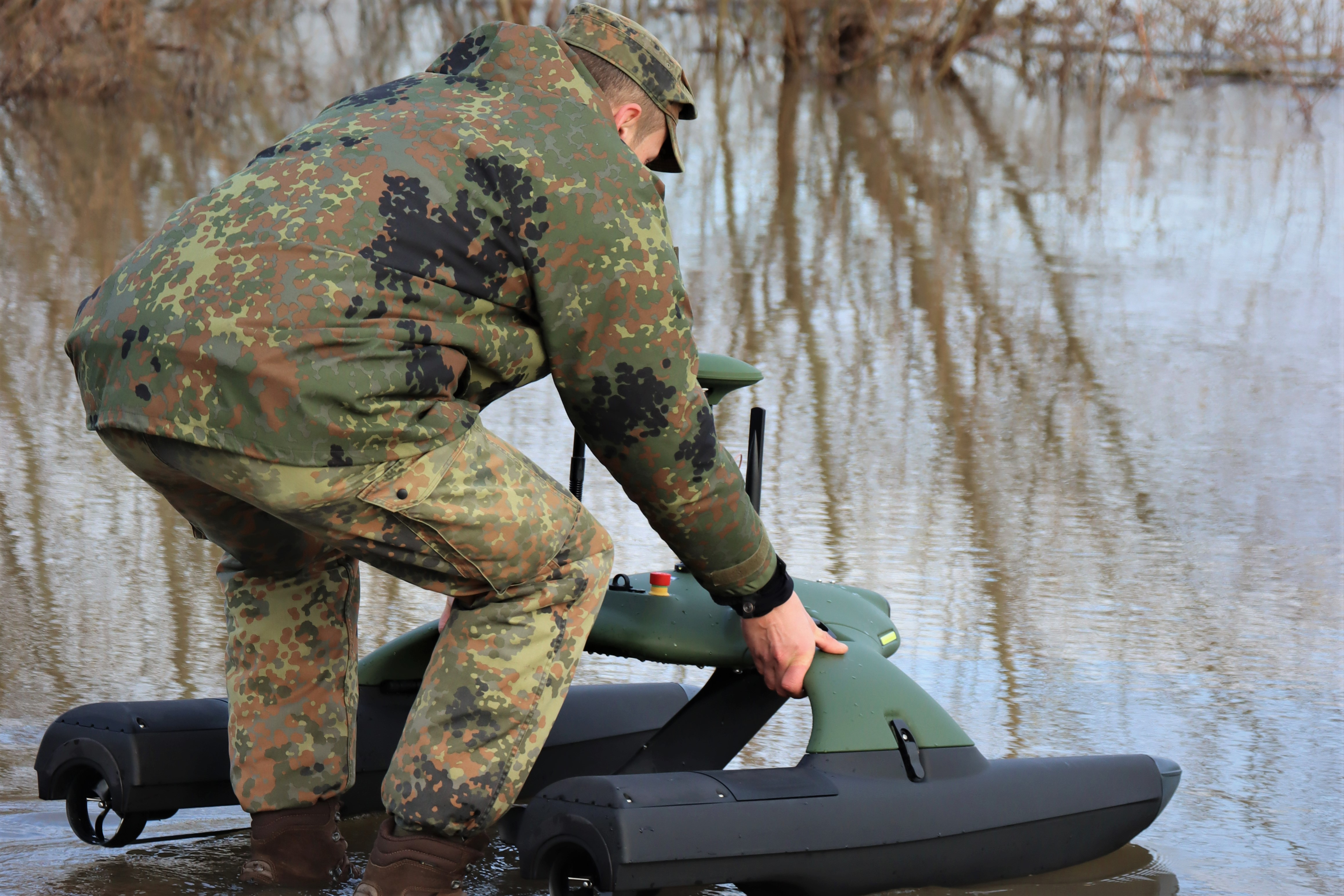 Ein Soldat setzt die Drohne auf das Wasser.