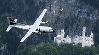 Eine Transall C-160 in silberner Sonderlackierung fliegt über Schloss Neuschwanstein im Allgäu