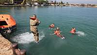 Ein Soldat springt mit Rettungsweste ins Hafenbecken. Vier weitere libanesische Soldaten schwimmen bereits mit Rettungsweste
