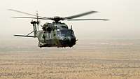 Ein NH-90 fliegt in Mali in großer Höhe über Steppenland.
