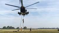 Soldaten seilen sich aus einem schwebenden Hubschrauber CH-53 ab