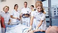 Ärzte und Krankenpfleger der Bundeswehr stehen am Krankenbett eines Patienten.