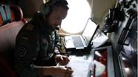 Ein Soldat in einem Flugzeug macht sich Notizen 