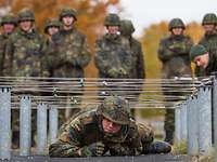 Soldat kriecht unter einem Hindernis durch