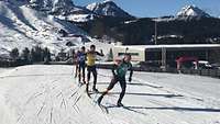 Vier Biathleten in einer Gruppe gemeinsam unterwegs.