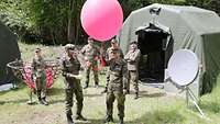 Soldaten nehmen das Wetter anhand eines Wetterballons auf.