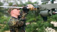Ein Soldat schraubt eine Antenne an