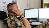 Ein Soldat telefoniert am Schreibtisch seines Büros 