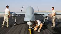 Drei Techniker bereiten die Drohne Heron 1 auf den Start vor