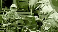 Zwei Soldaten bereiten Telefone für den Einsatz in einem Gefechtsstand vor.