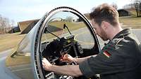 Alexander Müller inspiziert das Cockpit eines Eurofighters