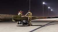 Techniker bereiten Bomben für den Einsatz an einem Kampfjet vor.