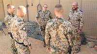 Drei Soldaten unterhalten sich mit der Truppenpsychologin und dem Truppenpsychologiefeldwebel