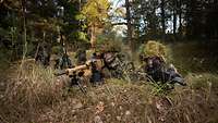 Zwei getarnte Soldaten mit Gewehren in Stellung im Wald