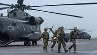 Vier Sanitäts-Soldaten bringen einen Verwundeten auf einer Trage vom Landeplatz des Hubschraubers CH-53 weg zum Feldlager.