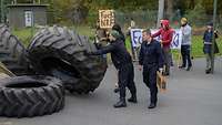 Statisten übernehmen die Rolle von Demonstranten. Mit Lkw-Reifen blockieren sie die Zufahrt zum Stützpunkt.