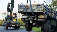 Mit einem Kran wird ein Bundeswehr-Lkw von der Straße gezogen.