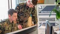 Zwei Soldaten im Betreuungsbüro sichten Angebote