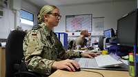 Eine Soldatin sitzt vor einem Computer im Einsatz