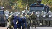 Soldaten setzen Demonstranten fest.