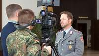 Ein Oberstabsgefreiter wird von einem Journalisten vor der Kamera ausgebildet