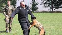 Nach Aufforderung des Hundeführers greift ein Diensthund der Schule für Diensthundewesen einen Mann in Schutzkleidung an.