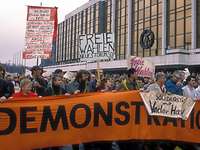 Menschen demonstrieren mit Transparenten vor dem Palast der Republik.