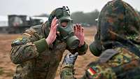 Ein Soldat streift sich die Atemschutzmaske vom Gesicht