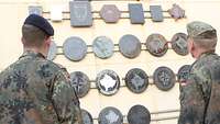Zwei Soldaten schauen auf ein Schild vor dem Hauptquartier der Kosovo Force
