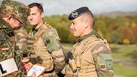 Ein deutscher Soldat überreicht einem französischen Soldaten eine Plakette als Anerkennung.
