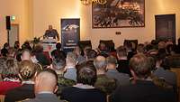 Angehörige und Gäste des Einsatzführungskommandos der Bundeswehr sitzen auf Stühlen und verfolgen die Rede General Pfeffers