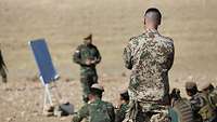 Ein deutscher Soldat schaut einem irakischen Soldaten bei der Ausbildung zu