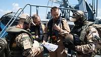 Vier Soldaten an Deck der Korvette, im Hintergrund ein Einsatzboot