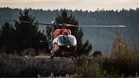 Ein Hubschrauber im Tiefflug über freiem Gelände