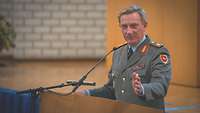 Ein deutscher General an einem Rednerpult und hält einen Vortrag.