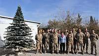 Ein Gruppenbild mit der Verteidigungsministerin und Soldaten. Links davon steht ein Weihnachtsbaum.