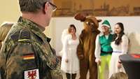 Soldat mit Weihnachtsfiguren im Hintergrund.