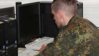 Ein Soldat sitzt vor einem Computer