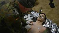 Ein Soldat übt Behandlungen an einer lebensgroßen Puppe.