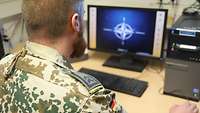 Ein Soldat sitzt vor einem Computer