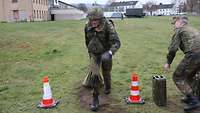 Ein Soldat mit Schutzweste und Helm zieht einen Sack