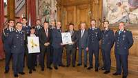 Beim Gruppenbild nach der Stadtratssitzung werden Patenschaftsurkunde und „Gelbe Schleife“ präsentiert