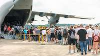 Besucher stehen in der Warteschlange vor einem Airbus A400M