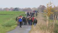 Boßelgruppe auf einem Feldweg beim Spielen