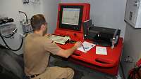 Ein Soldat sitzt an einem Computer und überwacht die Füllstände in den Tanks
