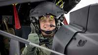 Ein Soldat mit Pilotenhelm lächelt in die Kamera und hält den Daumen hoch.