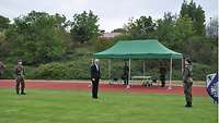 Die Kommandeurin begrüßt den Ehrengast auf dem Sportplatz, dort finden Gelöbnis und Vereidigung statt.