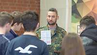 Das finden alle toll! Hauptfeldwebel Dennis Arend zeigt Schülerinnen und Schülern eines der vielen Formulare der Bundeswehr