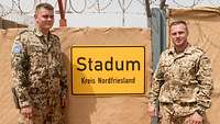 Portrait zweier Soldaten vor einem Ortsschild mit der Aufschrift „Stadum, Kreis Nordfriesland“