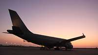 Ein Flugzeug der Bundeswehr steht in der Abenddämmerung auf dem Flughafen